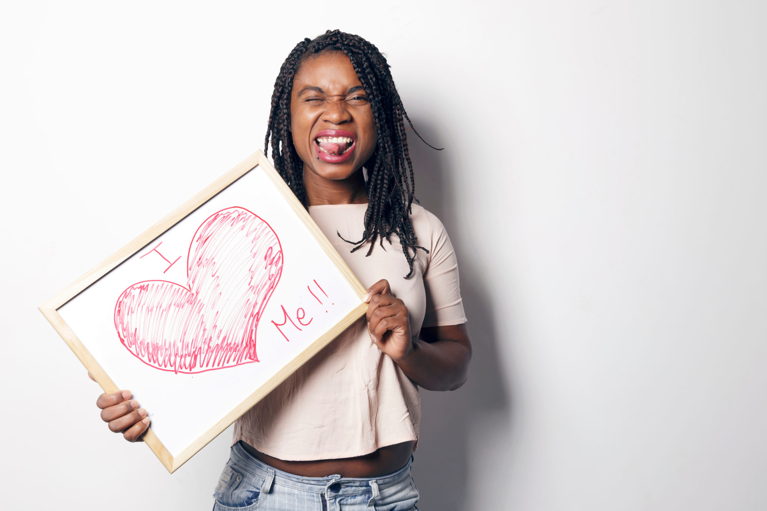 Happy young african woman holding an white board.
